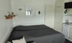 Living area with beds and kitchenette in 21 m² Levi apartment