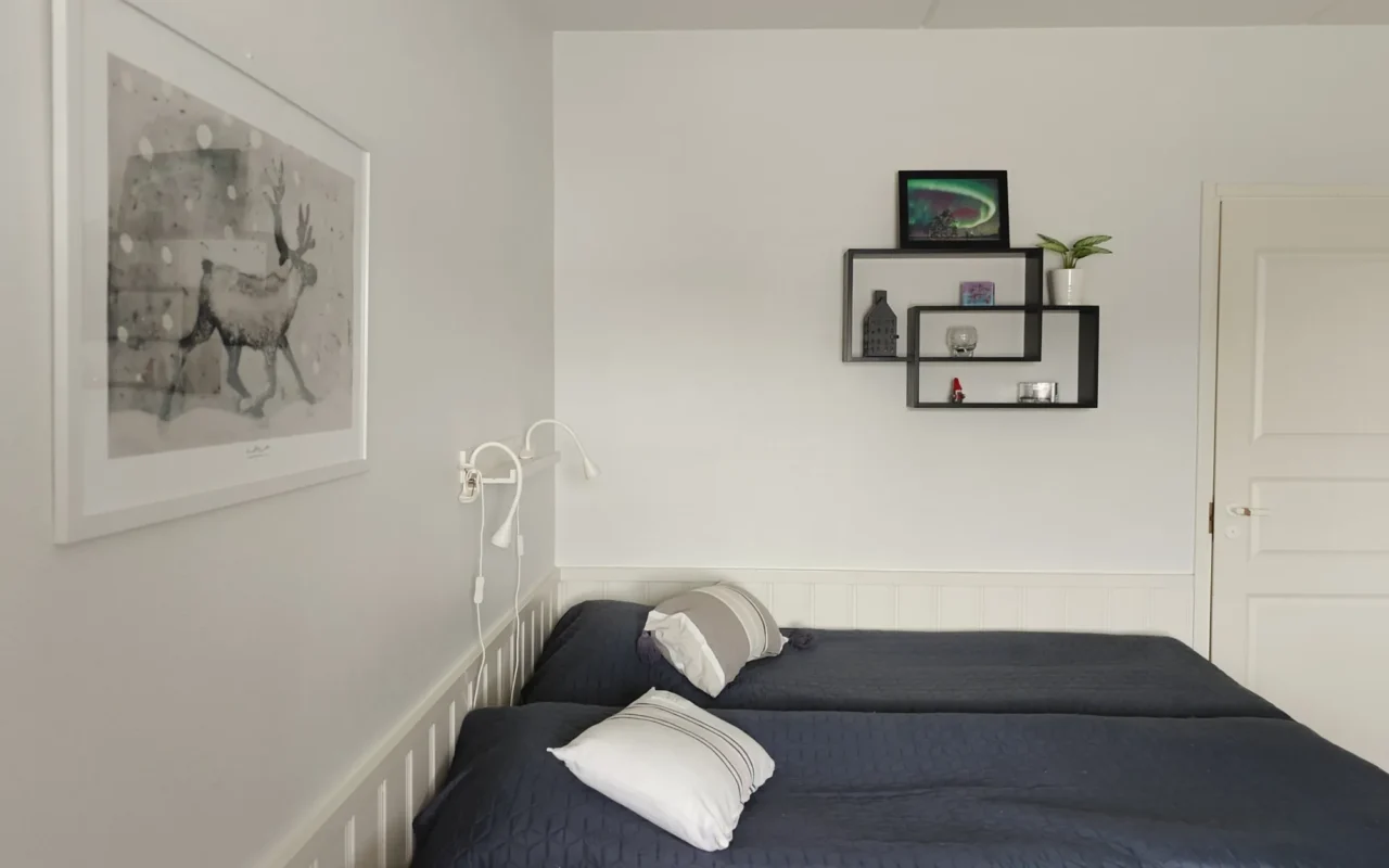 Two single beds with reading lights and a reindeer art print on the wall, 21 m² B, Levi