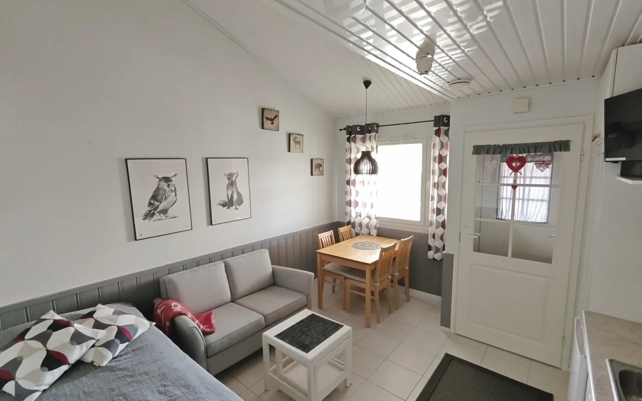 Living area of the 27 m² A split-level studio in Levi with bed, sofa, dining table and loft above