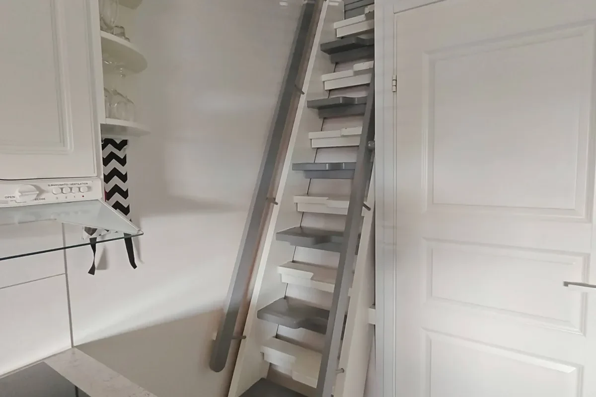 Steep narrow stairs up to the loft next to the kitchenette in the 27 m² A apartment
