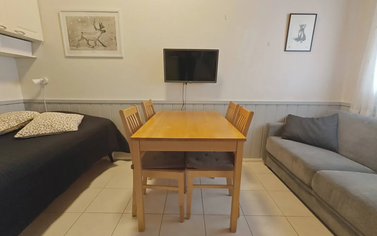 Dining table, sofa and bed in Leviloma 27 m² B apartment, Levi
