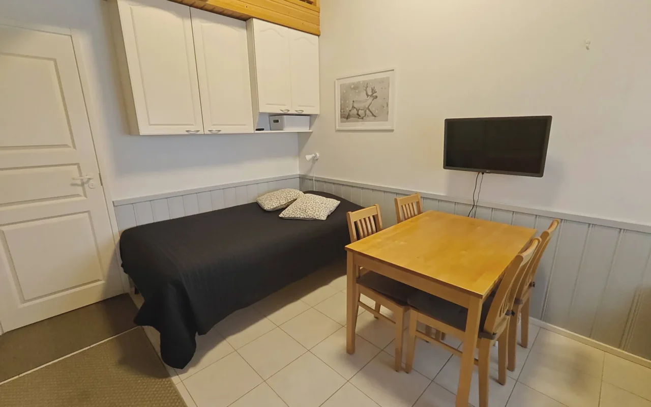 Living area with sofa and dining table in Leviloma 27 m² B apartment, Levi